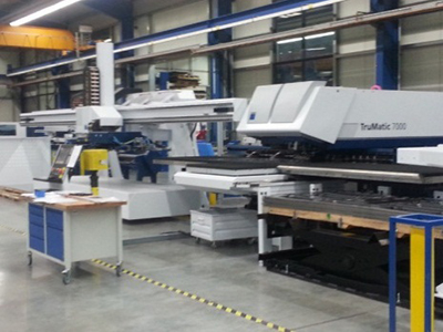 Eine moderne Stanzmaschine der Marke Trumpf (TruMatic 7000) in einer hochautomatisierten Werkshalle.